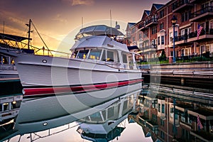 Boat and waterfront condominiums reflecting in the water at suns