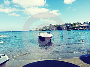 Boat In waters of beautiful Agia Pelagia bay at Crete island in Greece