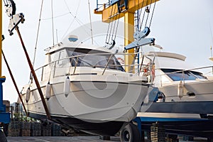 Boat wheel crane elevating motorboat to yearly paint