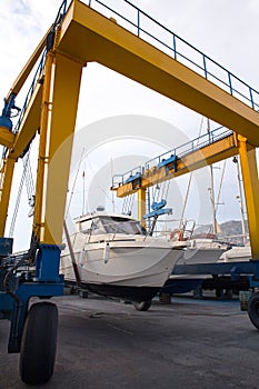 Boat wheel crane elevating motorboat to yearly paint