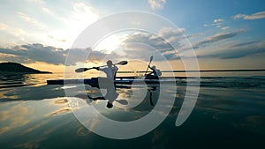 Boaters are kayaking along the sunset lake