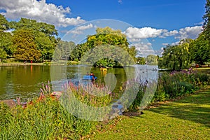 Boaters on lake in park, Birmingham, England