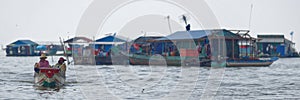 Boaters near huts of Tonle Sap, Cambodia