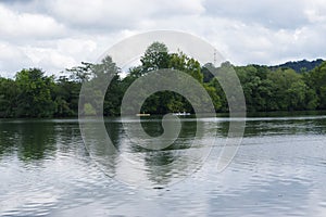 Boaters on a still lake with trees and water