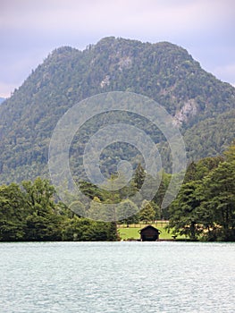 Boathouse with Mountain Background at Blue Water Sea