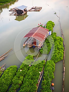 Boathouse on the river with floating garden raft