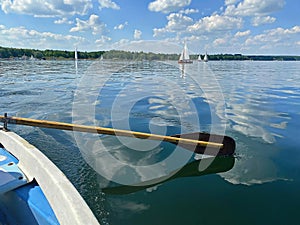 Boating on beautiful lake on blue sky and pleasant green landscape background and lovely reflection on water surface