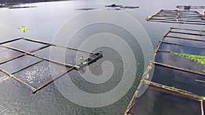 Boatman alighting tiny wooden fishing boat on mountain lake. Drone aerial