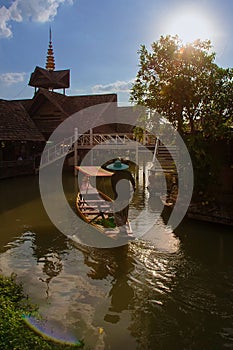 Boatman controls the empty wooden boat for tourist on floating market, Thailand