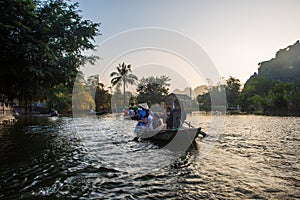 A boatman ferries tourists along the Halong Bay on land tourist attraction in Tam Coc, Vietnam.