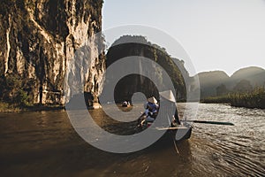 A boatman ferries tourists along the Halong Bay on land tourist attraction in Tam Coc, Vietnam.