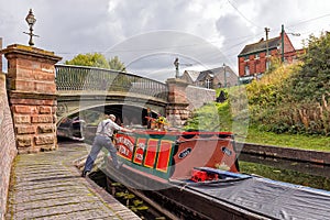 Boatman manoeuvring a Narrowboat, Dudley, West Midlands.