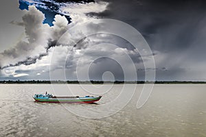 A boatman moving to city under summer cloudy sky