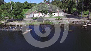 Boatman paddle tiny wooden fishing boat on mountain lake. Drone aerial