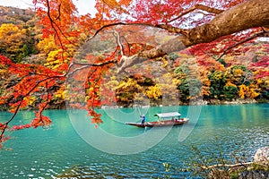 Boatman punting the boat at river. Arashiyama in autumn season along the river in Kyoto, Japan