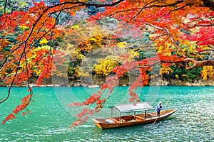 Boatman punting the boat at river. Arashiyama in autumn season along the river in Kyoto, Japan