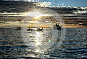 Boats against sunset sky with some heavy clouds