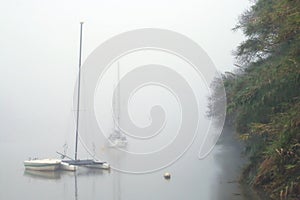 Boats anchored in the Guadiana river next to the town of SanlÃºcar de Guadiana, Huelva, Spain.