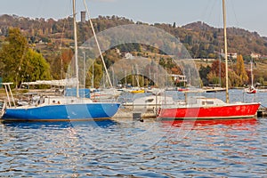 Boats anchored to the pier of Lake Viverone, it is the third   largest glacial lake ,in Piedmont,Italy