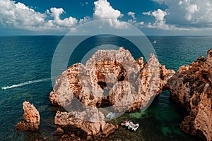 Boats anchored on a turquoise sea on the Portuguese Algarve coast.