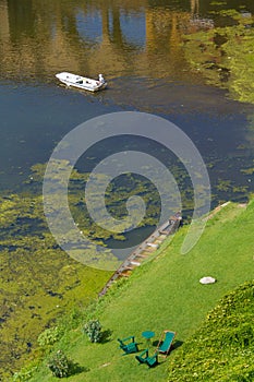 Boats in Arno Rive, Florencer and resting chairs at its bank