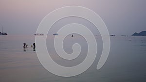 Boats in the background of a beautiful sunset at sea with a couple