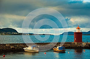 Boats and beacon in harbor. Alesund, Norway