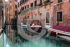 Boats in a canal between the buildings of Venice in Italy