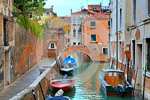 Boats on canal among houses. Venice, Italy.
