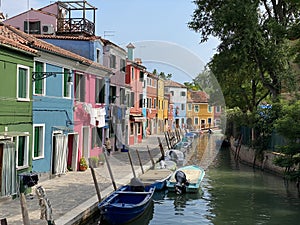 Boats and colorful traditional painted houses in a canal street houses of Burano island, Venice, Italy