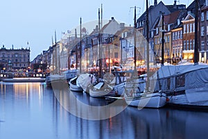 Boats in copenhagen canal harbor during night