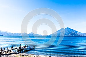 Boats docked at pier with Atitlan & Toliman volcanoes, Lake Atitlan, Guatemala