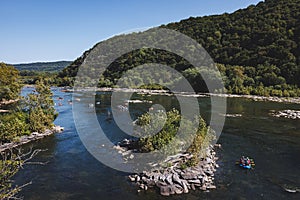 Boats drifting in the center of a river close to a woodland: Harper's Ferry, West Virginia