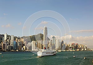 Boats & ferries navigate in Victoria Harbor with the prominent landmark  among crowded skyscrapers in Hong Kong