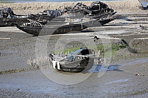Boats of fishermen stranded in the mud at low tide on the river Malta near Canning Town, India