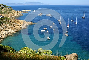 Boats floating off the coast in Cannelle Bay, Giglio Island Italy photo