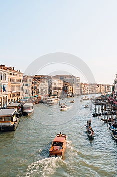 Boats and gondolas navigating through Grand Canal and the buildings from Rialto bridge in Venice, Italy