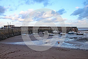 Boats in the harbour at Minehead in Somerset. The tide is out and the sky is stormy