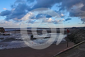 Boats in the harbour at Minehead in Somerset. The tide is out and the sky is stormy