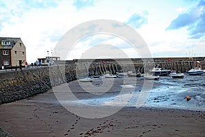 Boats in the harbour at Minehead in Somerset. The tide is out and the sky is stormy