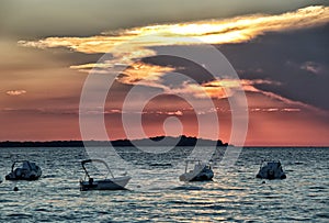 Boats harboured on the sea under the stormy cloud by sunset