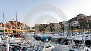 Boats and hotels in the fishing marina in Cabo San Lucas near sunset