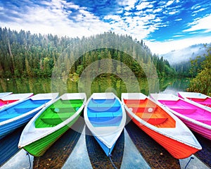 Boats on majestic mountain lake Lacul Rosu or Red Lake or Killer Lake