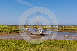 Boats moored in an estuary of Brancaster Bay near Burnham, Norfolk, UK