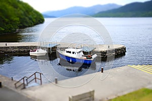 Boats moored harbour harbour stone pier jetty water two miniature scenic view landscape loch Lomond Inversnaid Scotland