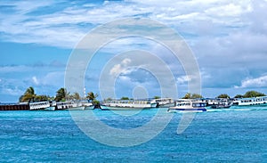 Boats moored at Male Harbor, Maldive island on a sunny blue cloudy sky
