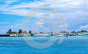 Boats moored at Male Harbor, Maldive island on a sunny blue cloudy sky