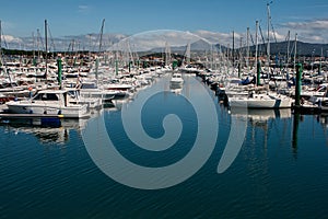 Boats moored in port and one preparing to leave the port photo