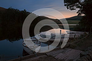 Boats moored to the shore of a night lake