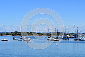 Boats moored in a vibrant harbor under clear blue skies